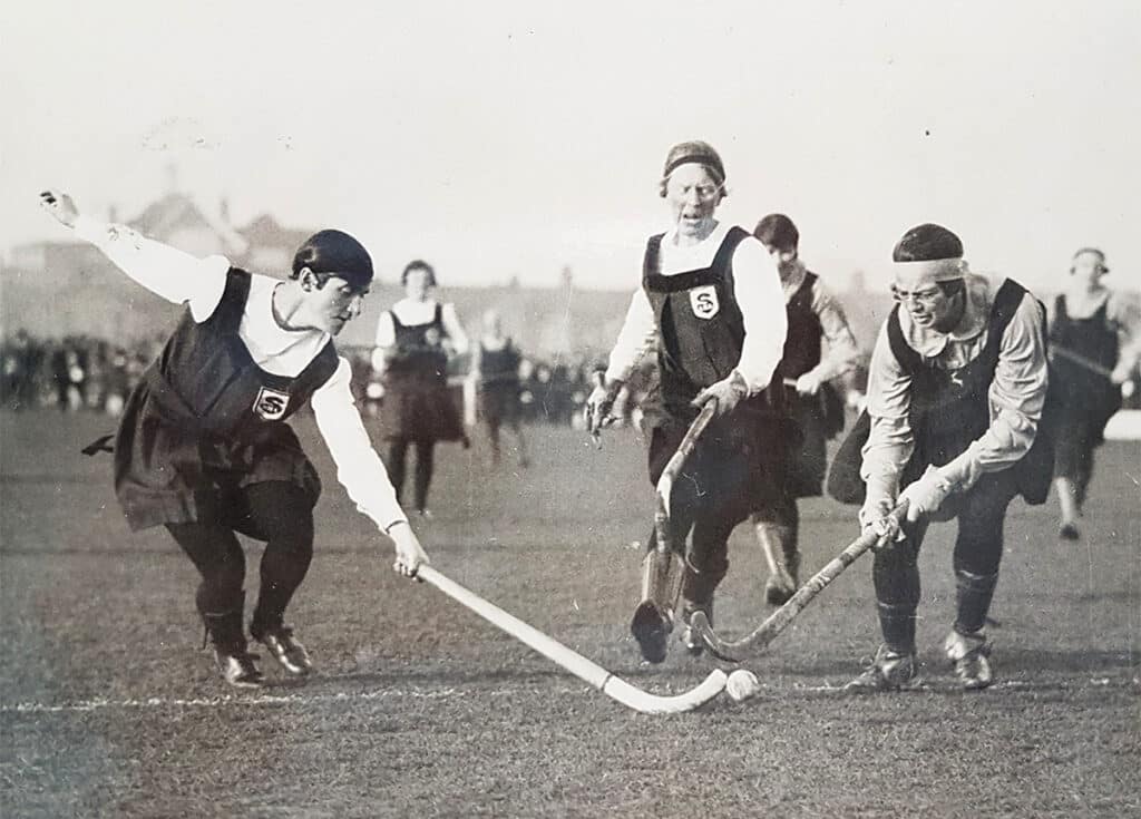 A women's players challenging for the ball and others watching on