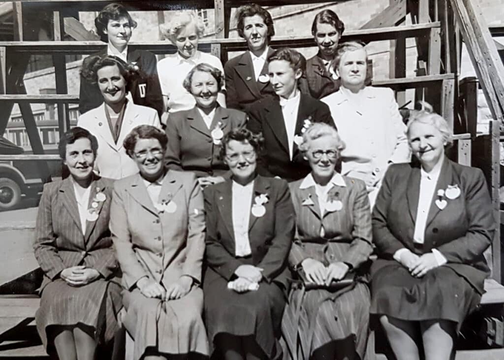 A black and white image of 13 women, seated in business wear