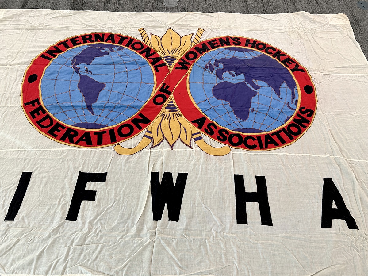 The front of a white flag with the logo of the IFWHA laid out