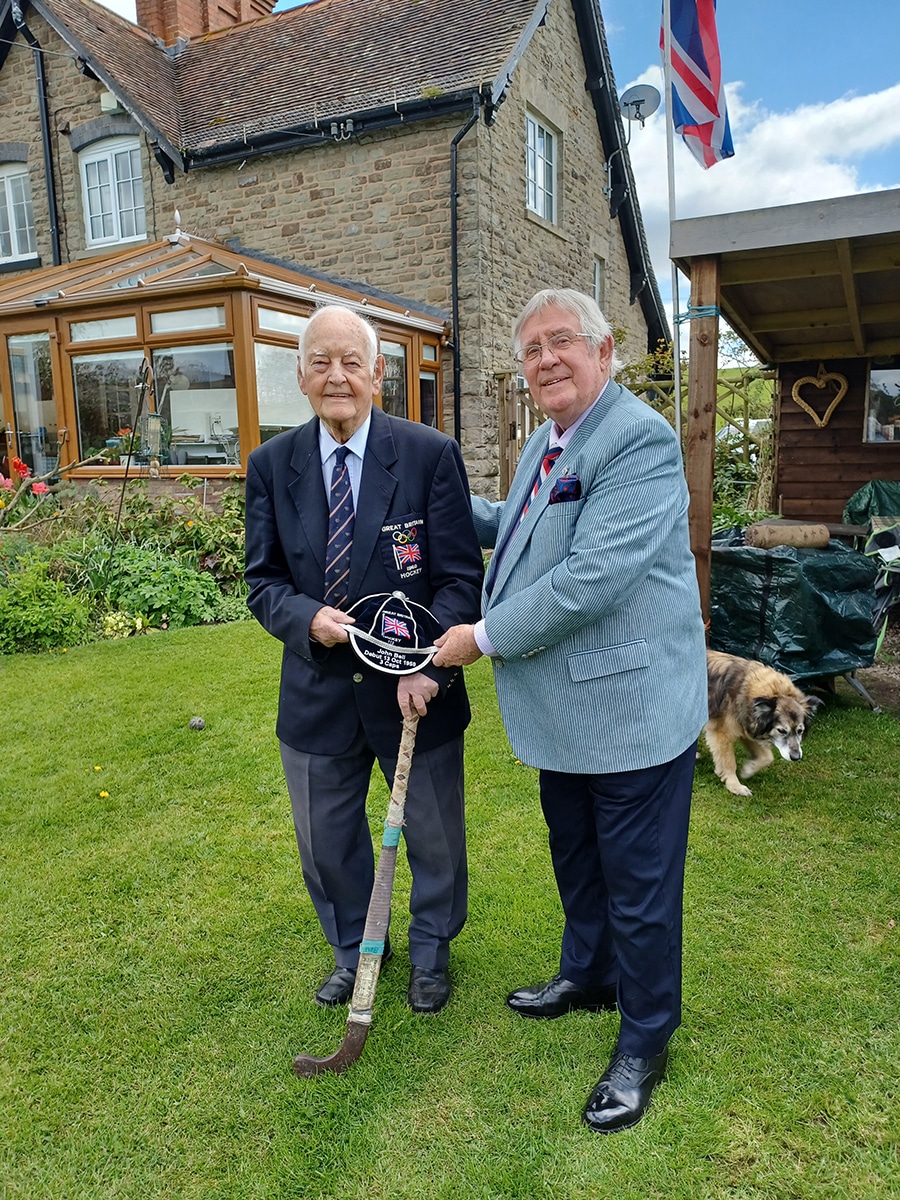 An image of Dr. John Bell receiving his honours cap from The Hockey Museum President and Hon. Curator Mike Smith.