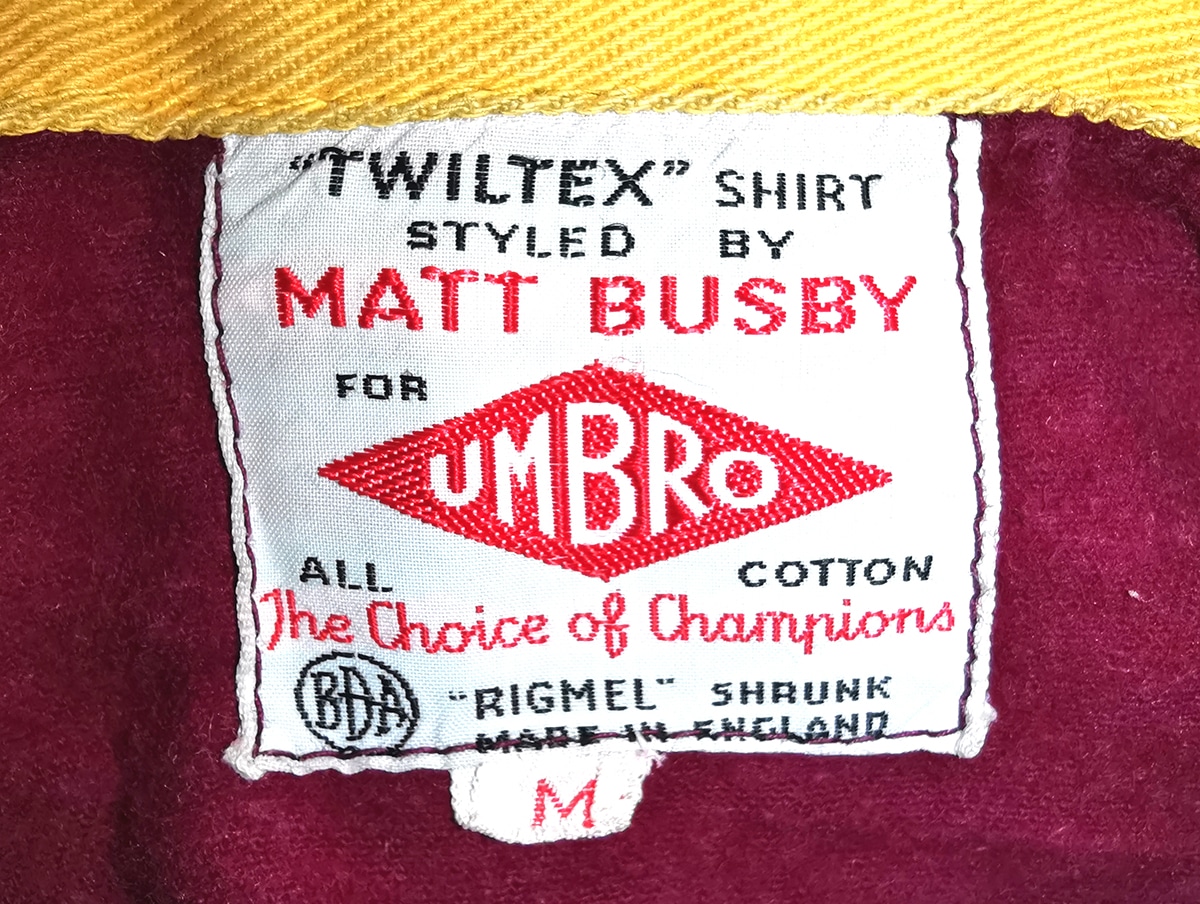 An image of the detail of the inside label of the Umbro shirt, it reads "Styled by Matt Busby for Umbro"