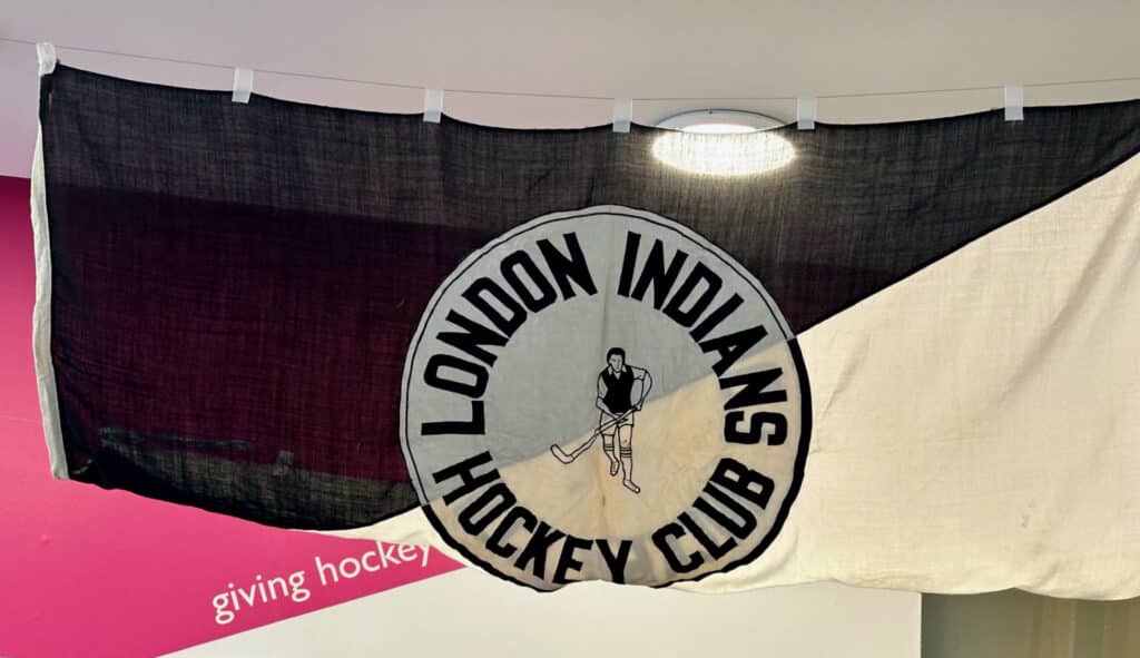 The London Indians HC flag on display at The Hockey Museum. It is a black and white flag, with the crest of a hockey player in the middle.