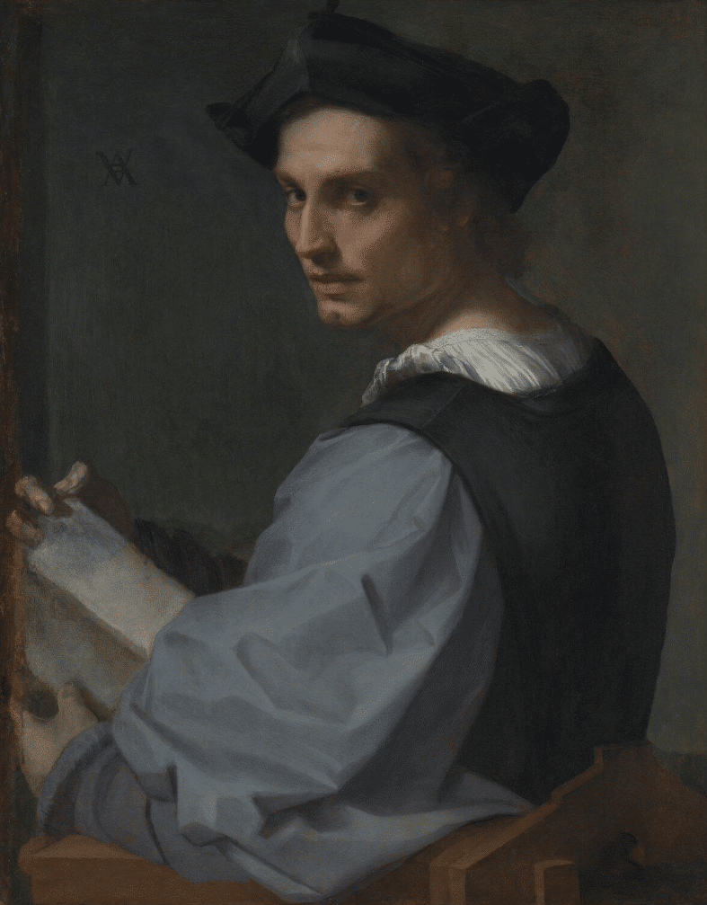 A photo-realistic oil painting from the Italian Renaissance. A pale-skinned young man sits in a wooden chair with his body facing left, his back slightly turned away but his head turning to face the viewer. He is holding an open book in his hands as if disturbed from reading. He is wearing a soft-fabric black hat with brown curly hair falling over his ears and across the back of his neck. The hat he wears has three points (jutting out at the front and either side of his head over his ears); the angular features of his nose and chin reflect the pointed shape of his hat. The man wears a loose-fitting, light blue blouse with billowing sleeves over a simple white shirt. Both garments are covered by a black tunic that might be a kind of painter's overall.