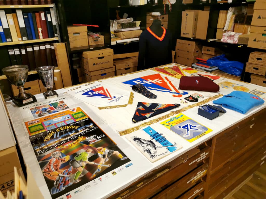 A workspace desk covered with multiple items of hockey memorabilia