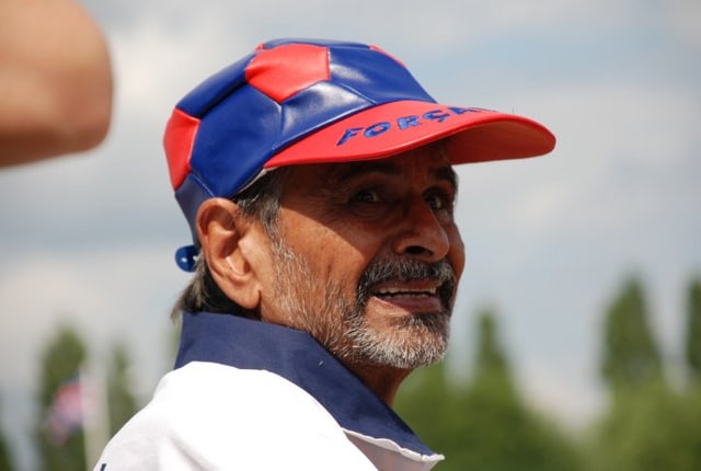 A colour image of a man in a sports cap looking past the camera.