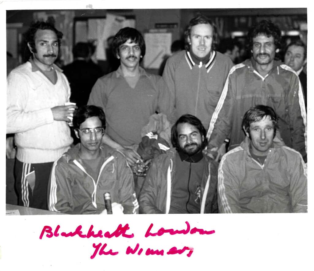 A black and white image of a men's hockey team (Blackheath Hockey Club) looking at the camera. Ethnically, the players are a mix of South Asian and Caucasian heritage.