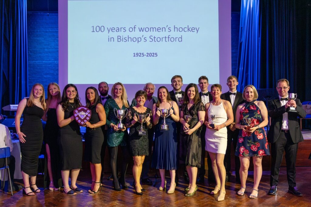 A colour photo of a group of 10 women and 7 men at an awards ceremony looking at the camera