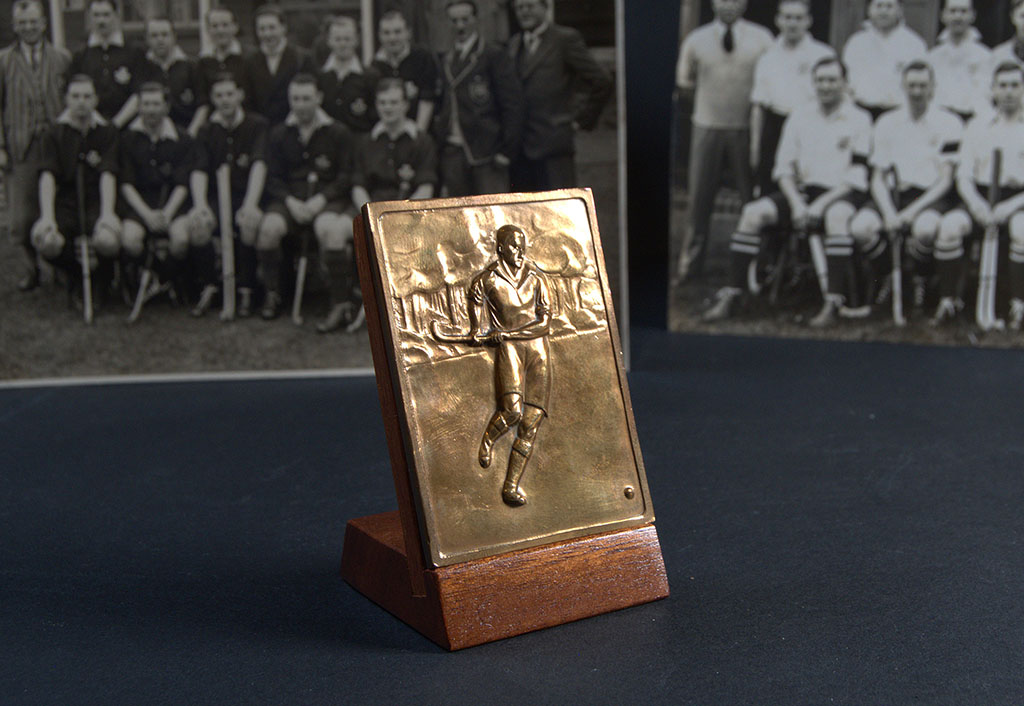The back of a medallion showing a hockey player 