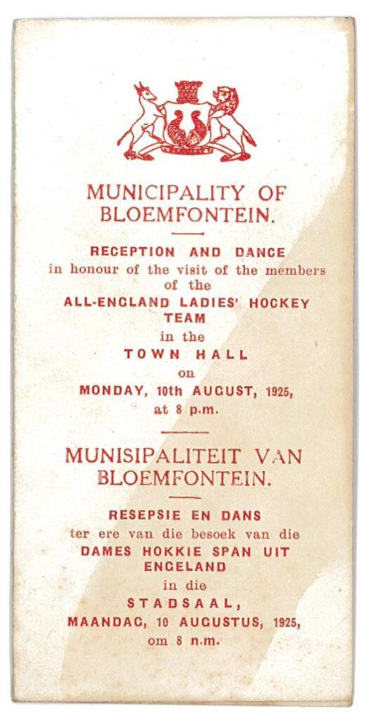 A yellowing front page of a programme with red text headed up by a logo made of a gazelle and lion either side of a shield.