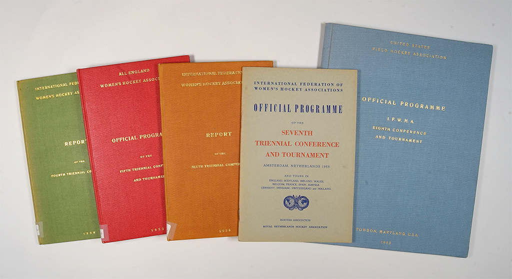 A collection of five vintage booklets, including reports and official programmes. The booklets, in various colours like green, red, orange, and blue, are neatly arranged on a flat surface, conveying a sense of historical significance and nostalgia.