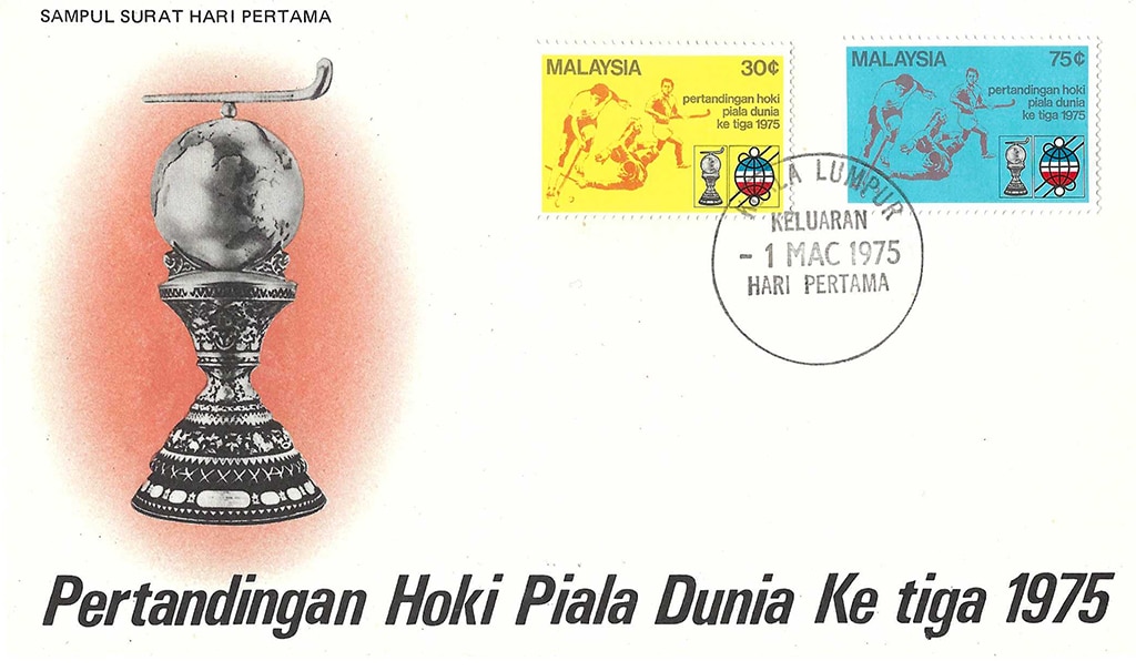 The front cover of an envelope. On the left half is a large, ornate trophy of a hockey stick above a globe. In the top right are two stamps with hockey scenes, one yellow and one light blue.