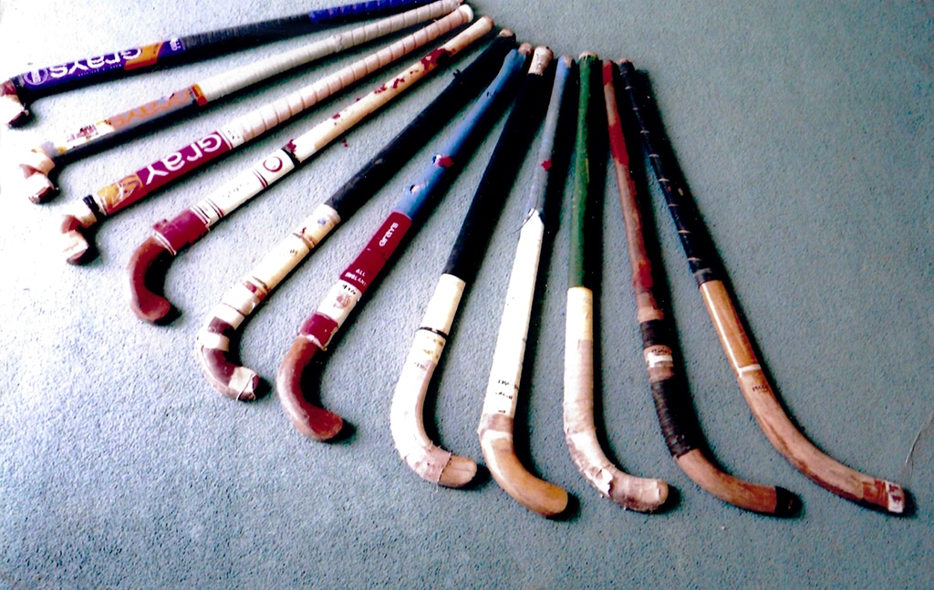 Eleven hockey sticks of varying shapes arranged in a fan shape.