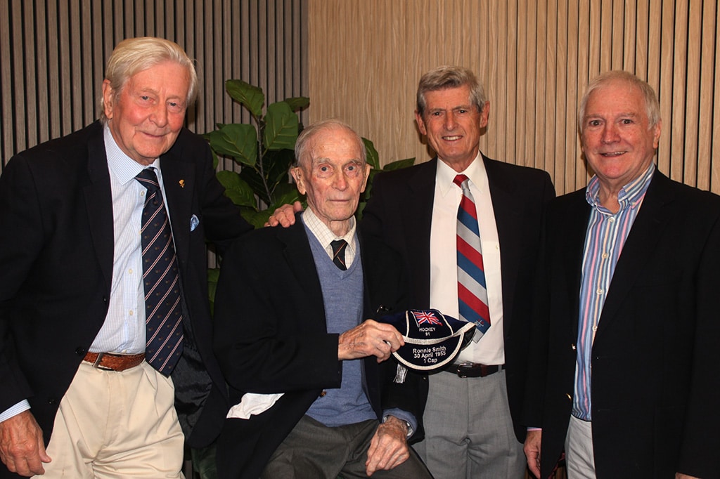 An elderly man being presented with a cap