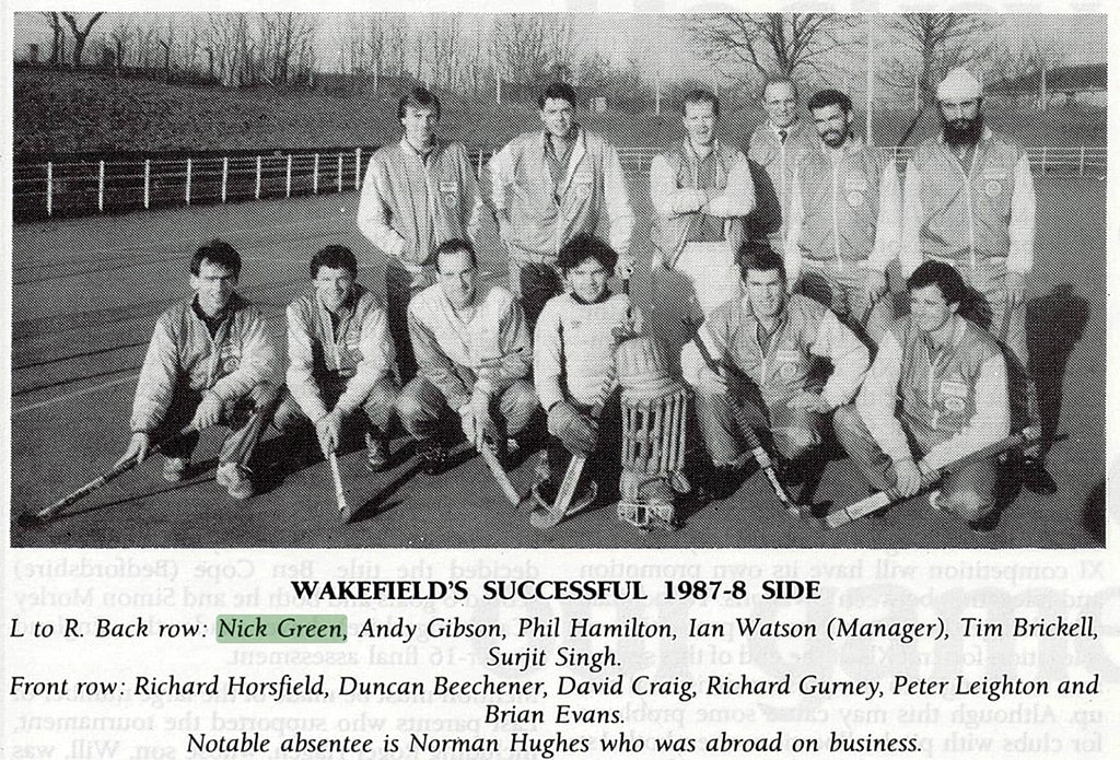 A men's hockey team in two rows, one standing, one crouched.