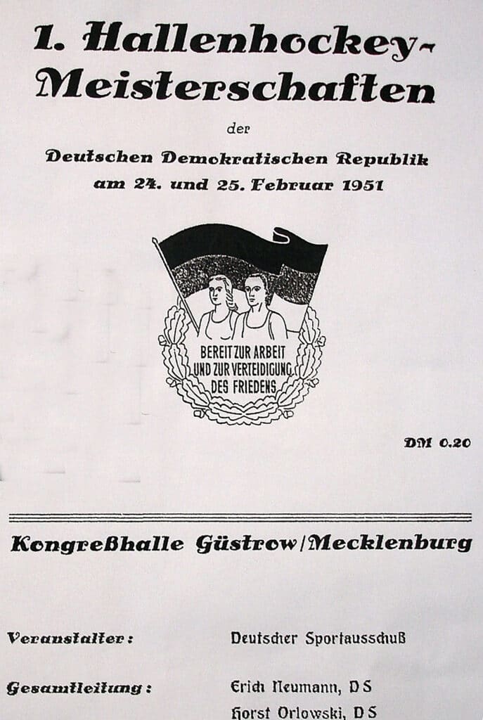 Cover page of a German event programme. The central image depicts a man and a woman before a large German flag within a wreath,