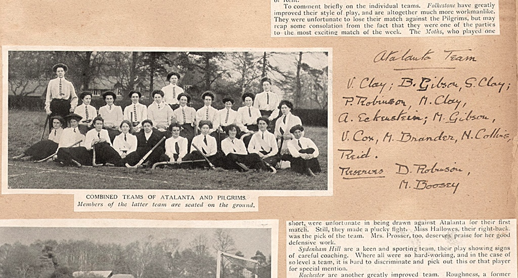 A photograph of two rows of seated women wearing long skirts, white blouses and long ties. The photograph is a cutting from a magazine which has been pasted into a scrapbook.