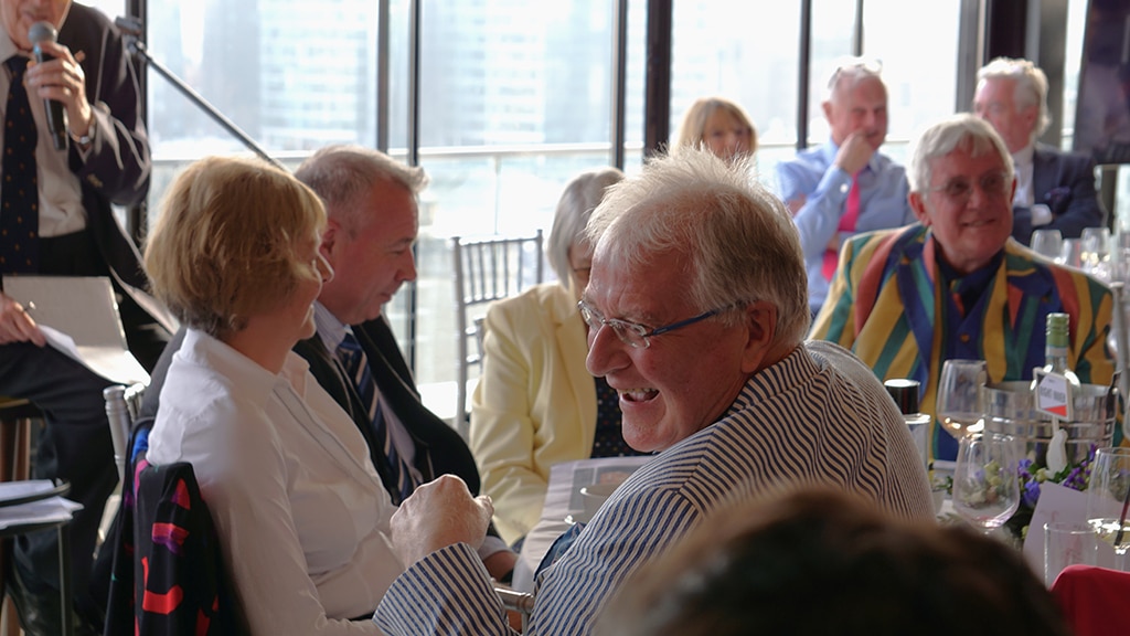 Men and women sitting at a round table laughing.