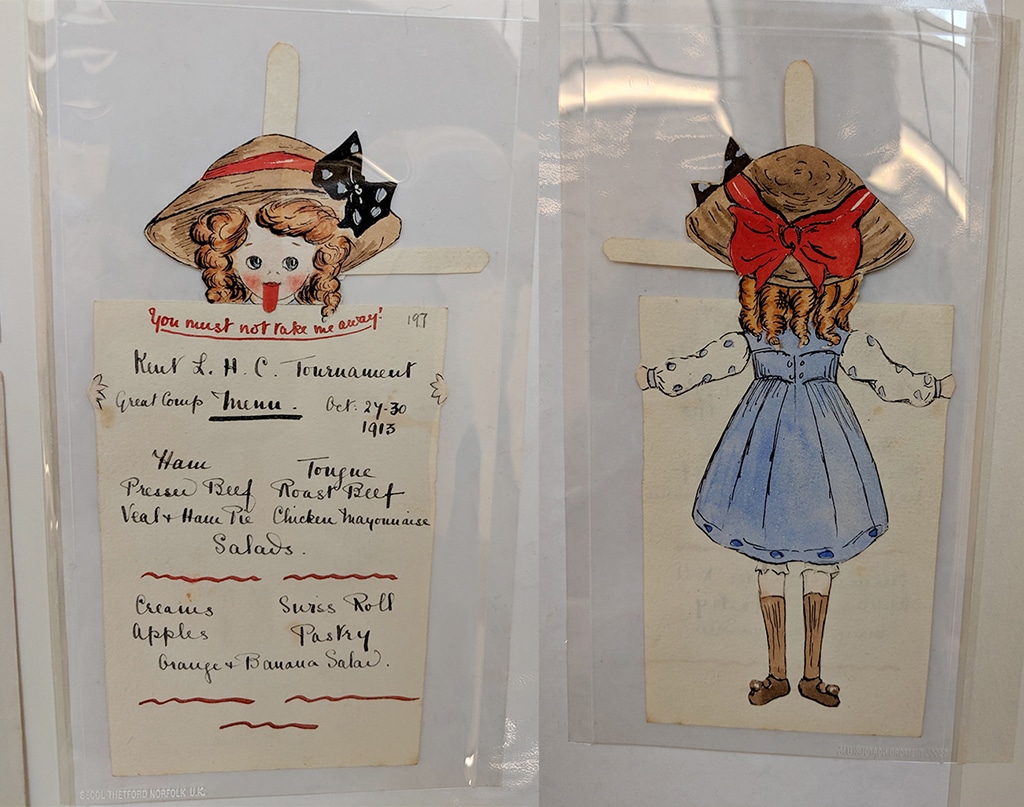 A menu card featuring a cartoon hockey girl with her tongue out wearing a light blue tunic and a big boater hat with a large red ribbon.