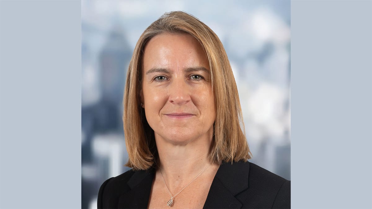 Katy Roberts landcape Profile photograph of a woman with shoulder-length straight brown hair against a blue background