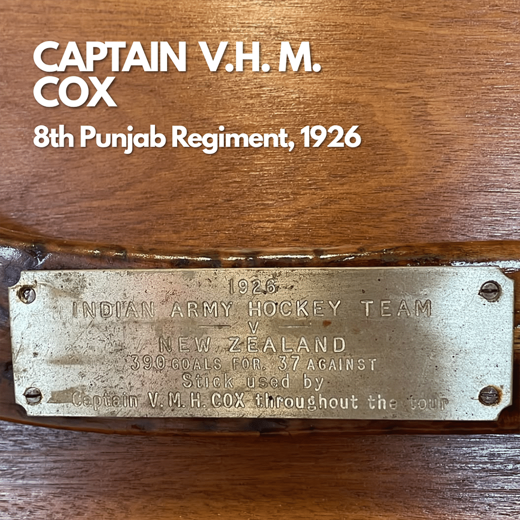 Close up image of a metal plaque on a wooden hockey stick.