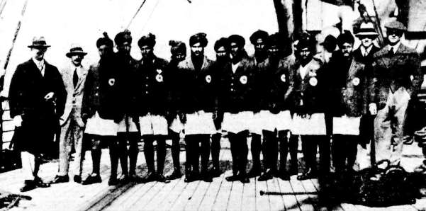 Black-and-white photograph of a hockey team and officials standing in a line on the deck of a ship.