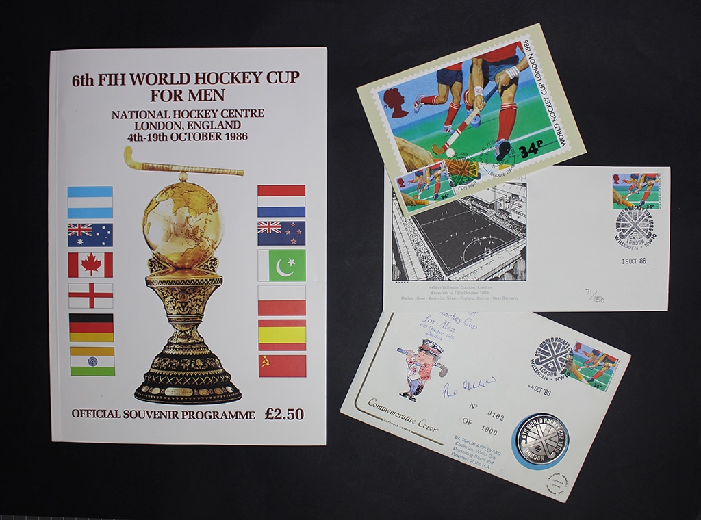 A large booklet and several envelopes and postcards displayed against a black background.