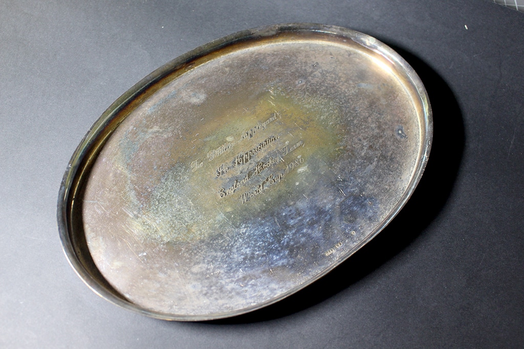 A silver presentation dish photographed against dark grey background.